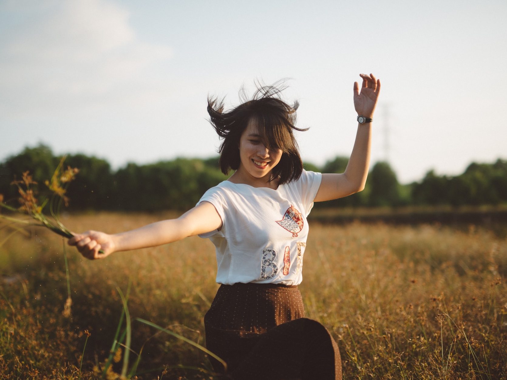 woman holding flower on field